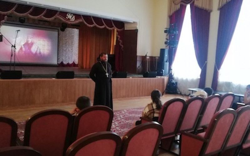 Дети смотрят фильм вместе со священником