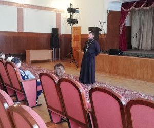 Дети смотрят фильм вместе со священником